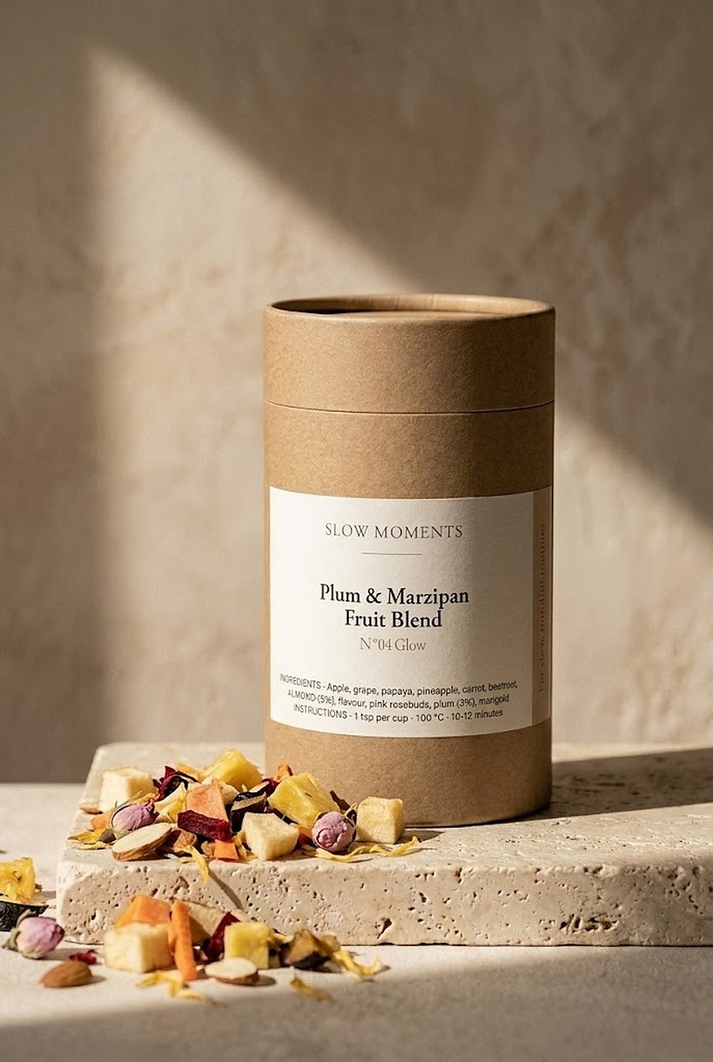 Koker Plum and Marzipan losse fruitthee van Slow Moments op een travertijn plint